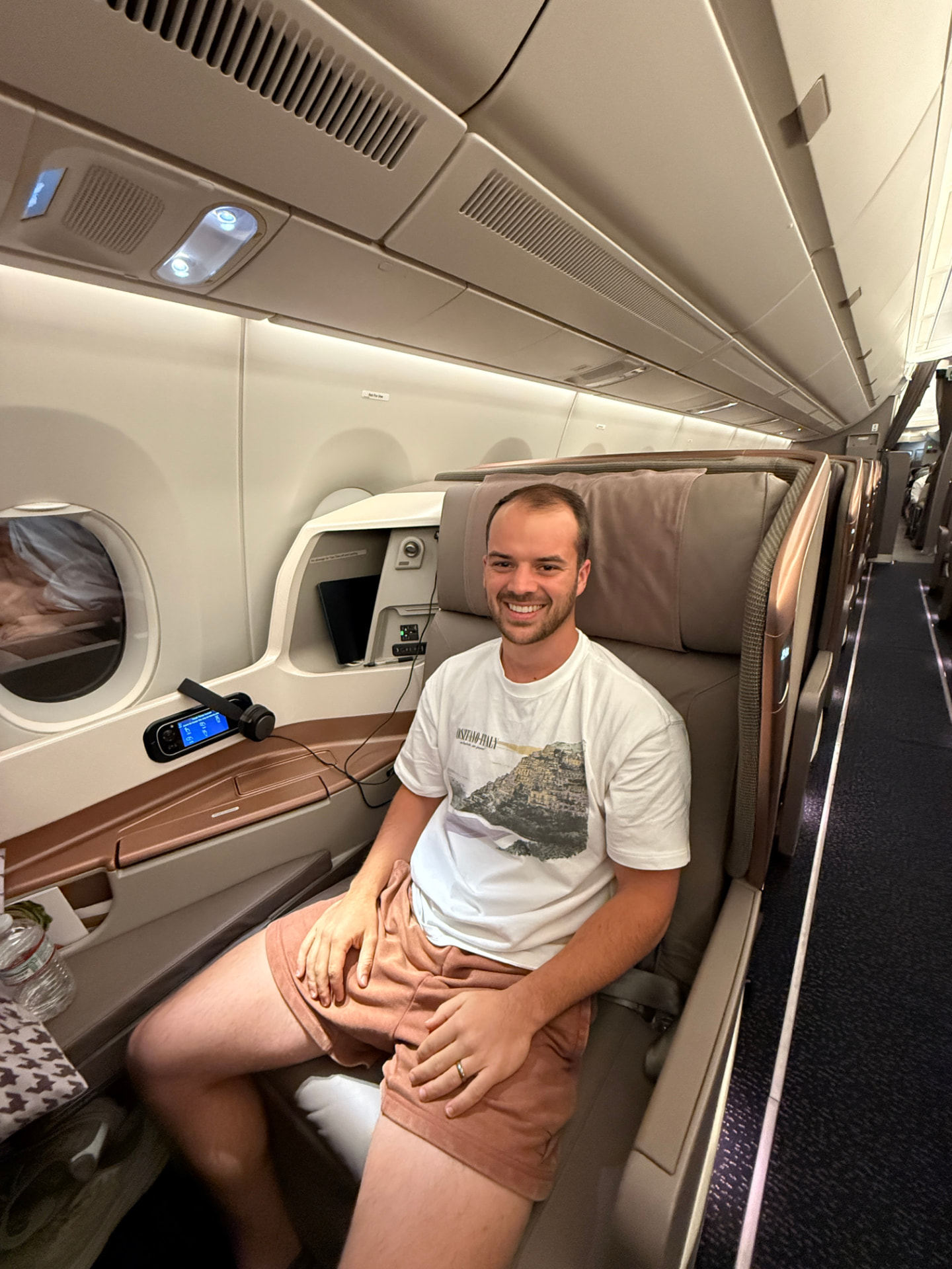 Joseph smiling in a lie-flat business class seat