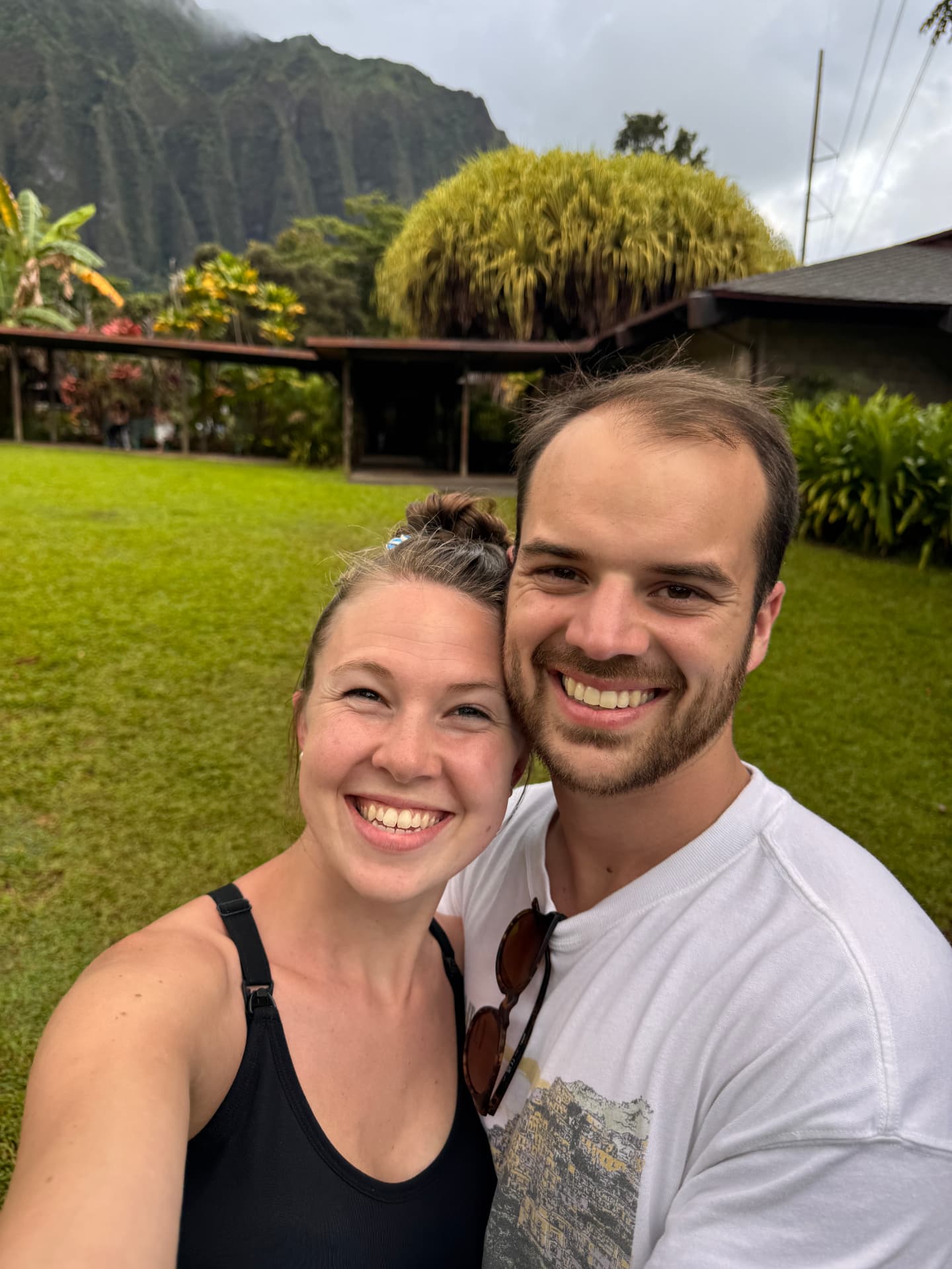 Joseph and his partner smiling in front of green mountains